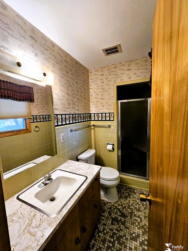 504 N Plum St, Shickley, NE 68436 - full bathroom featuring tile walls, a stall shower, wallpapered walls, vanity, and tile patterned floors