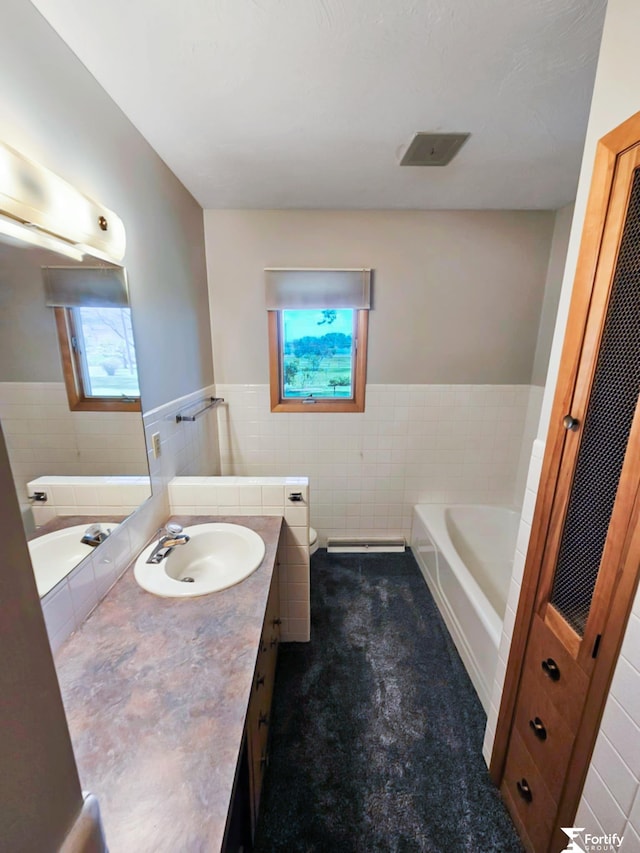 504 N Plum St, Shickley, NE 68436 - full bath with tile walls, a wainscoted wall, a garden tub, vanity, and toilet