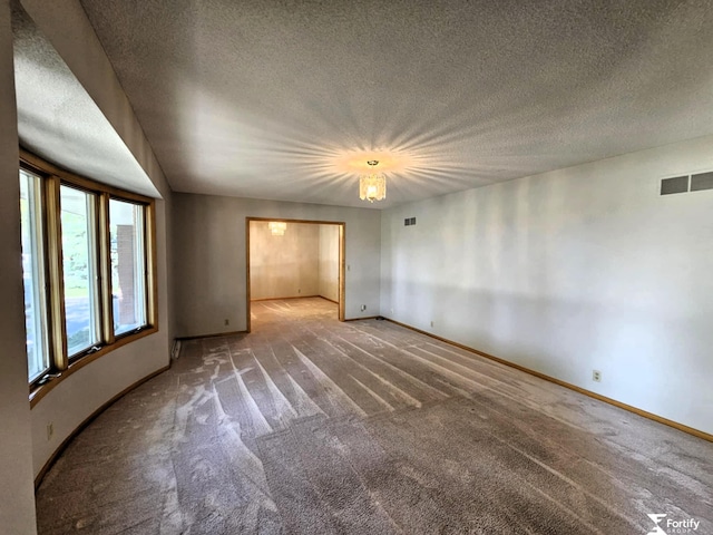 504 N Plum St, Shickley, NE 68436 - spare room featuring carpet, a textured ceiling, and baseboards