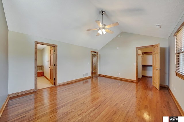 empty room featuring light wood finished floors, visible vents, baseboards, lofted ceiling, and ceiling fan