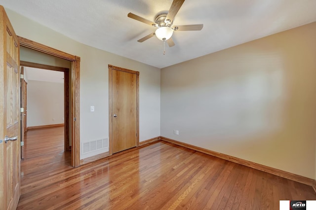 unfurnished bedroom featuring a ceiling fan, light wood-type flooring, visible vents, and baseboards