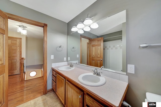 bathroom featuring tile patterned flooring, a sink, and double vanity