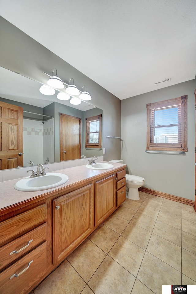 bathroom featuring tile patterned flooring, visible vents, a sink, and double vanity