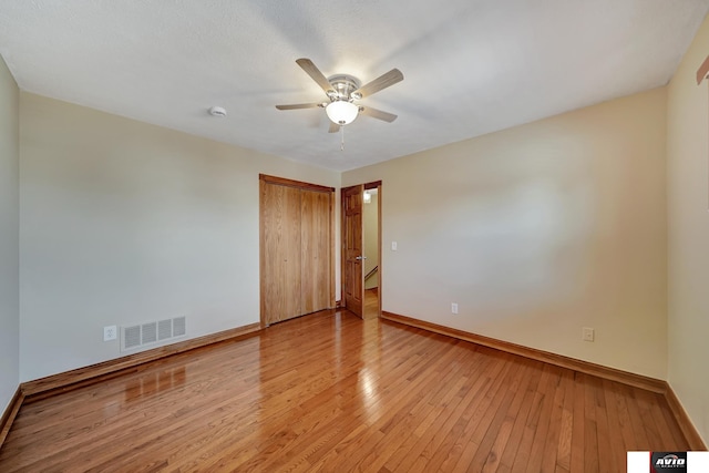 spare room featuring a ceiling fan, baseboards, visible vents, and light wood finished floors