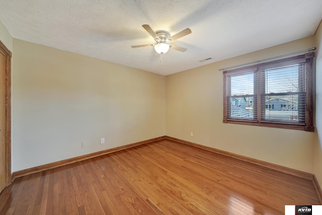 empty room with baseboards, visible vents, ceiling fan, a textured ceiling, and light wood-type flooring