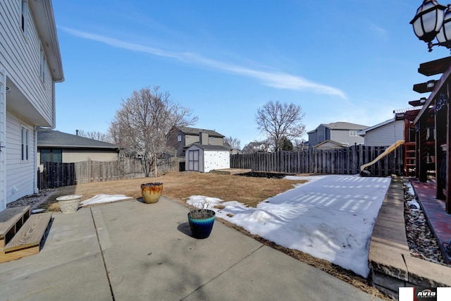 view of yard with a fenced backyard, a storage unit, an outdoor structure, a patio area, and a playground