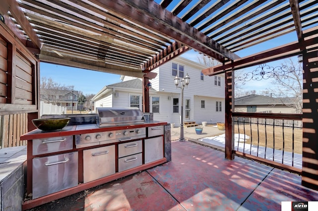 view of patio featuring area for grilling, fence, a pergola, exterior kitchen, and a residential view