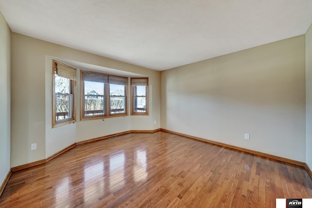 empty room with light wood finished floors and baseboards