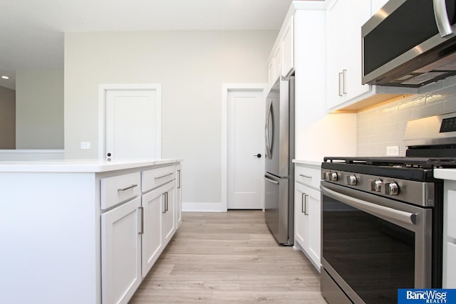 kitchen featuring white cabinetry, stainless steel appliances, and light countertops