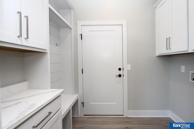 laundry room with washer hookup, cabinet space, baseboards, and wood finished floors