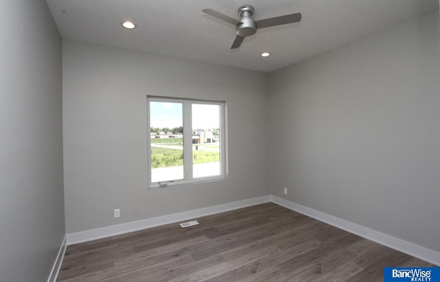 spare room with dark wood-type flooring, recessed lighting, visible vents, and baseboards