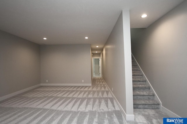 basement with light carpet, stairs, baseboards, and recessed lighting