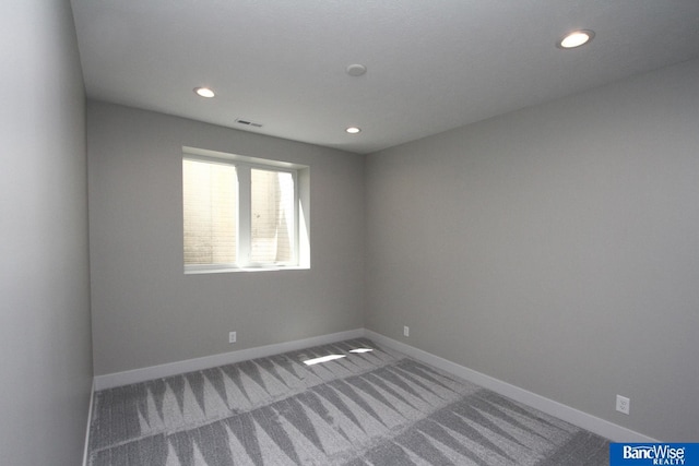 carpeted spare room featuring recessed lighting, visible vents, and baseboards