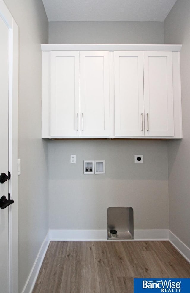 washroom featuring washer hookup, cabinet space, electric dryer hookup, and baseboards