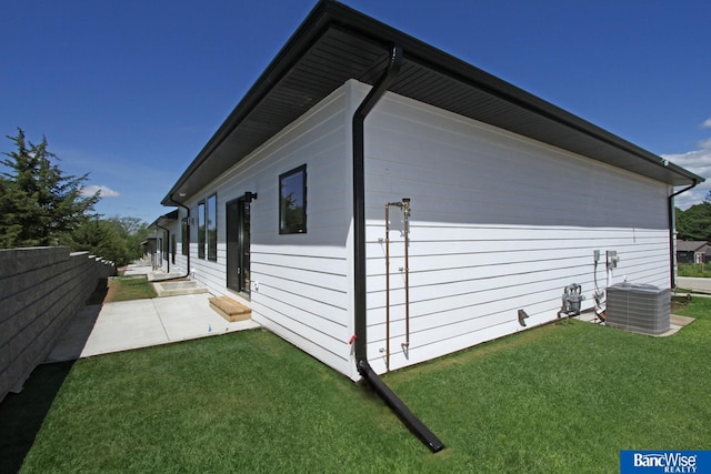 view of side of home with a yard, entry steps, a patio area, and fence