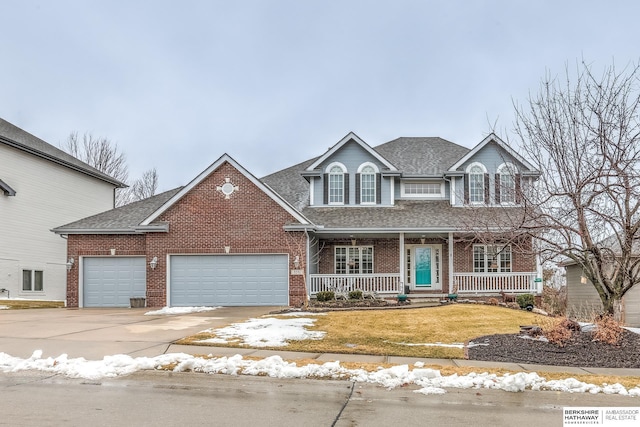 traditional home featuring a garage, a porch, a front lawn, and brick siding