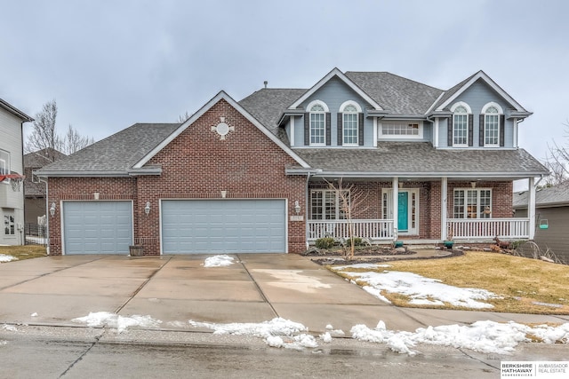 traditional-style house featuring an attached garage, covered porch, brick siding, a shingled roof, and concrete driveway