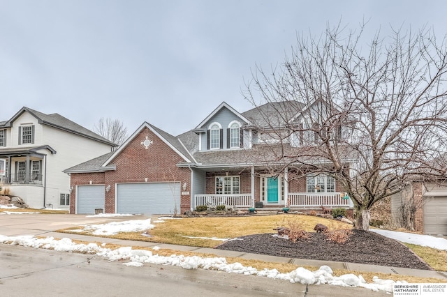 view of front of home with a garage, covered porch, driveway, and brick siding