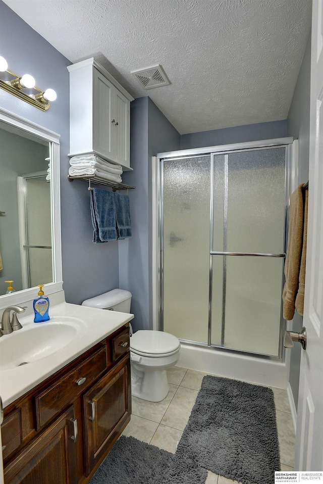 full bath featuring tile patterned flooring, visible vents, a shower stall, vanity, and a textured ceiling