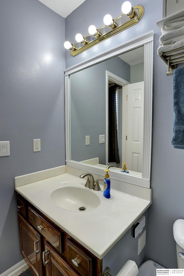 bathroom featuring toilet and vanity