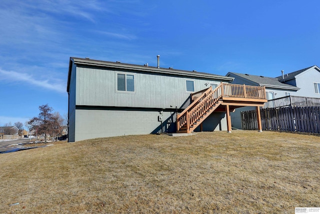 rear view of house with stairway, a yard, a deck, and fence