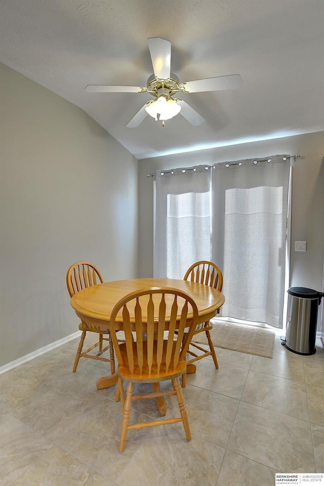 dining area with light tile patterned flooring, a ceiling fan, and baseboards