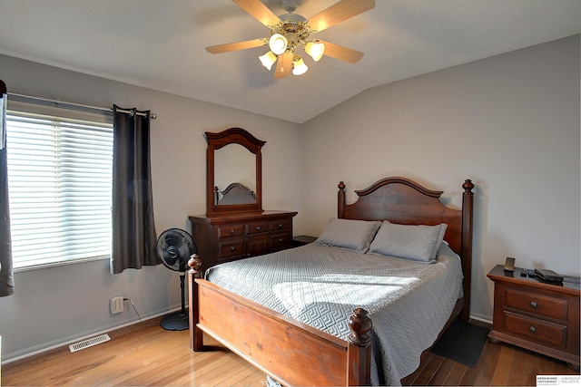 bedroom featuring visible vents, light wood-style flooring, lofted ceiling, and ceiling fan