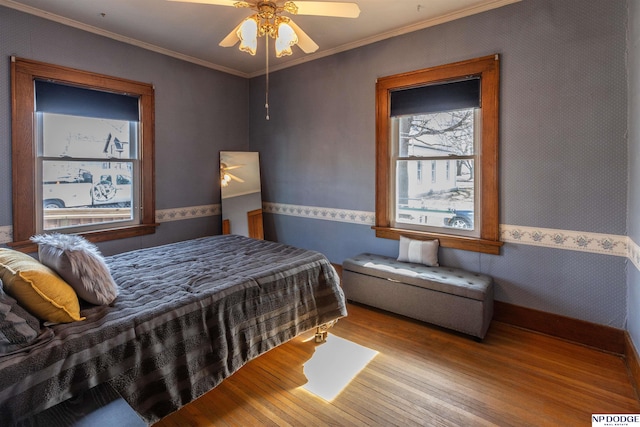 bedroom featuring ornamental molding, ceiling fan, and light wood-style flooring