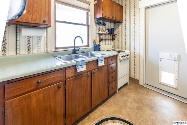 kitchen with wallpapered walls, brown cabinetry, light countertops, white electric range, and a sink