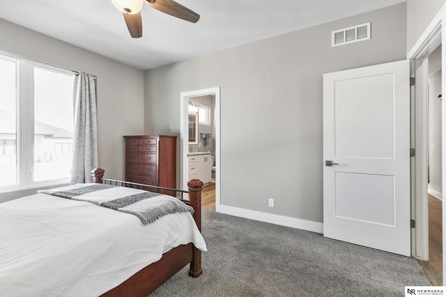 bedroom featuring dark colored carpet, visible vents, connected bathroom, ceiling fan, and baseboards