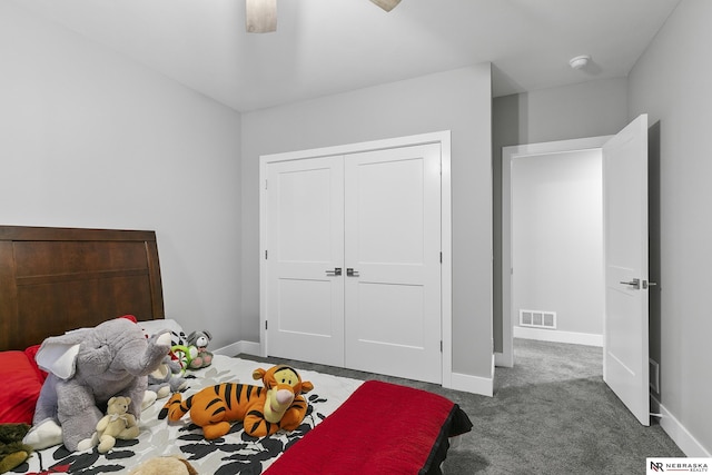 bedroom with baseboards, visible vents, a ceiling fan, dark colored carpet, and a closet