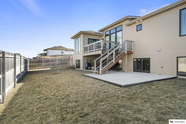 rear view of house featuring a fenced backyard, a patio, stairway, and a lawn