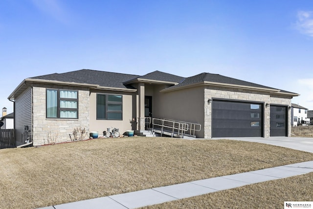 prairie-style home with an attached garage, stone siding, driveway, and a front lawn