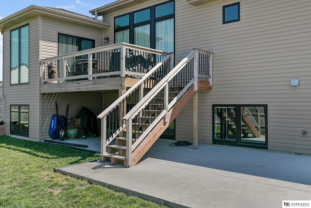 rear view of house with a patio area, stairs, and a lawn