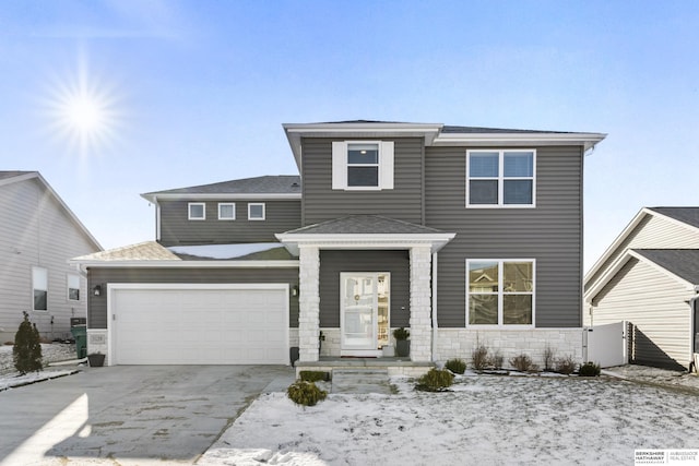 view of front facade featuring a garage, stone siding, driveway, and roof with shingles