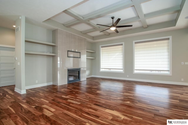 unfurnished living room featuring a large fireplace, dark wood-style flooring, coffered ceiling, and baseboards