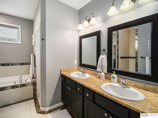 full bath featuring tile patterned flooring, a sink, a bath, and baseboards