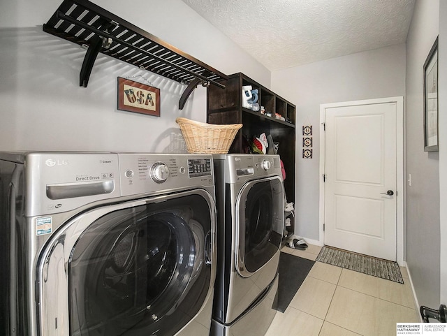 laundry room featuring laundry area, baseboards, a textured ceiling, separate washer and dryer, and light tile patterned flooring