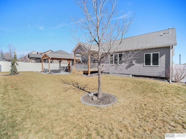 back of property with fence, a lawn, and a gazebo