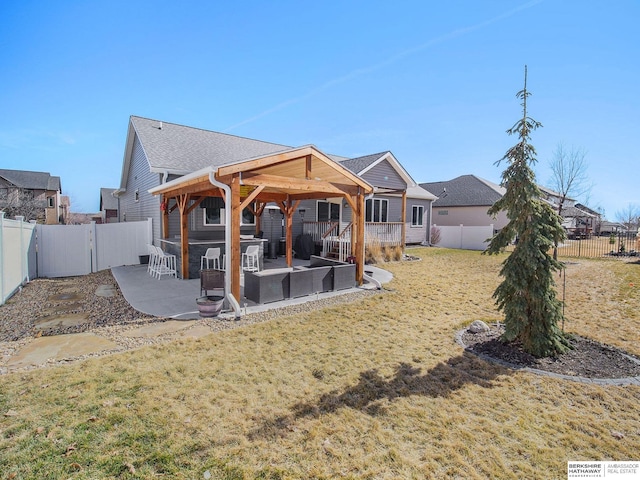 rear view of property featuring a patio area, a fenced backyard, and a lawn