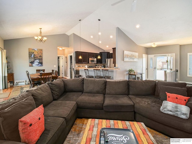 living area featuring vaulted ceiling and ceiling fan with notable chandelier