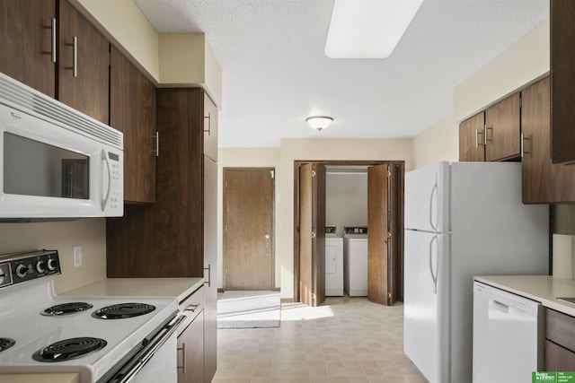 kitchen featuring washing machine and dryer, white appliances, light countertops, and a textured ceiling