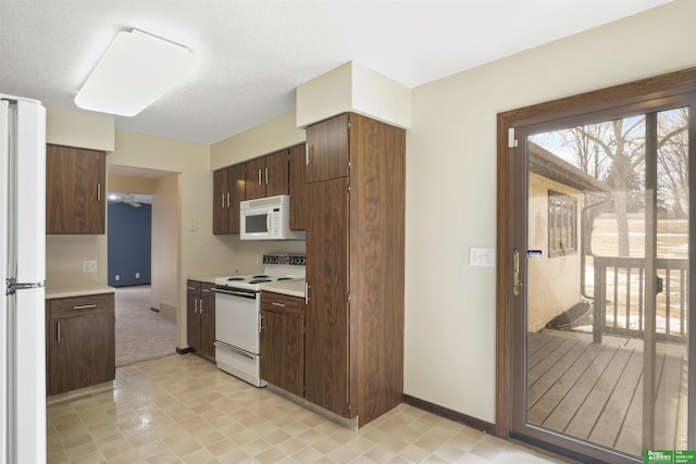 kitchen featuring light countertops, white appliances, dark brown cabinetry, and baseboards