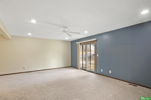 unfurnished room with light colored carpet, visible vents, a textured ceiling, and baseboards