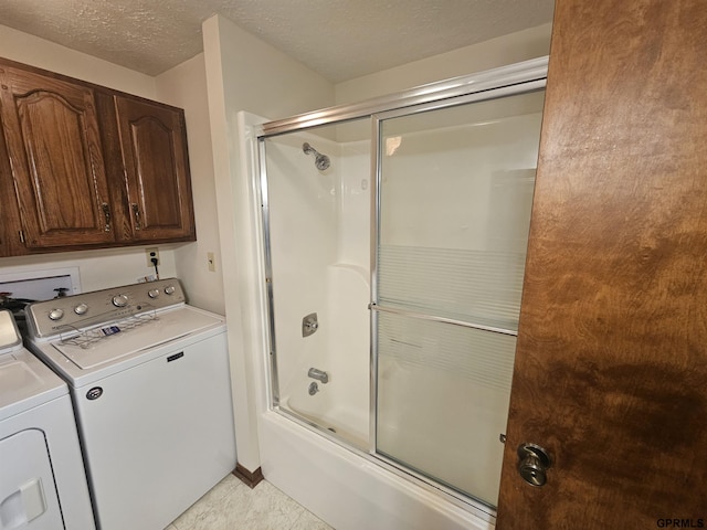 bathroom with washing machine and dryer, enclosed tub / shower combo, a textured ceiling, and tile patterned floors