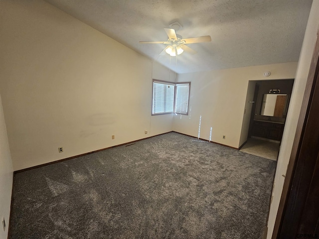 unfurnished bedroom featuring baseboards, lofted ceiling, ceiling fan, carpet, and a textured ceiling