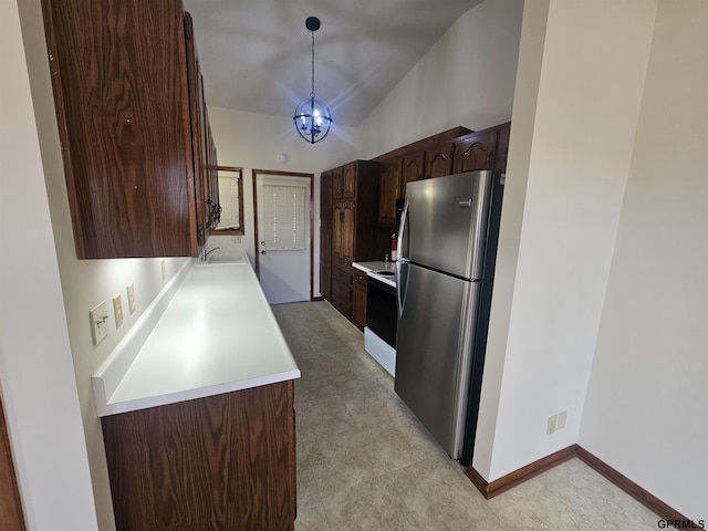 kitchen featuring dark brown cabinetry, range with electric cooktop, freestanding refrigerator, vaulted ceiling, and light countertops