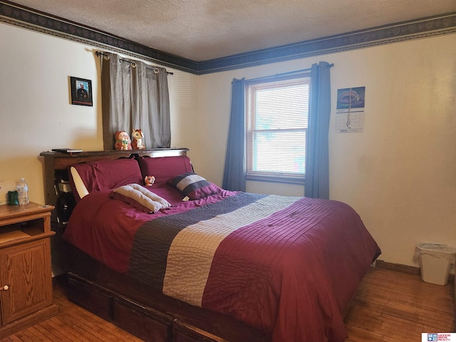 bedroom with a textured ceiling and hardwood / wood-style floors