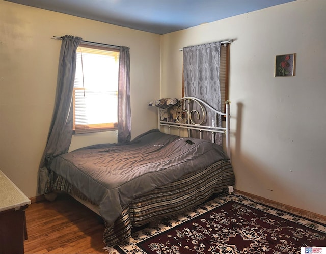 bedroom with baseboards and wood finished floors