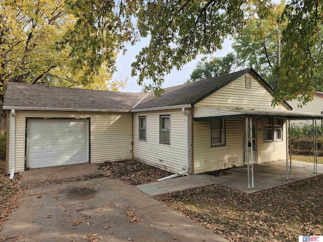 single story home with a garage, concrete driveway, and a shingled roof